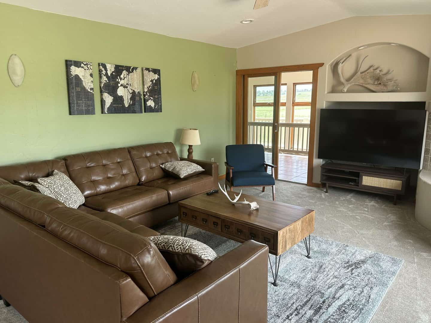 living room with sectional leather sofa and television