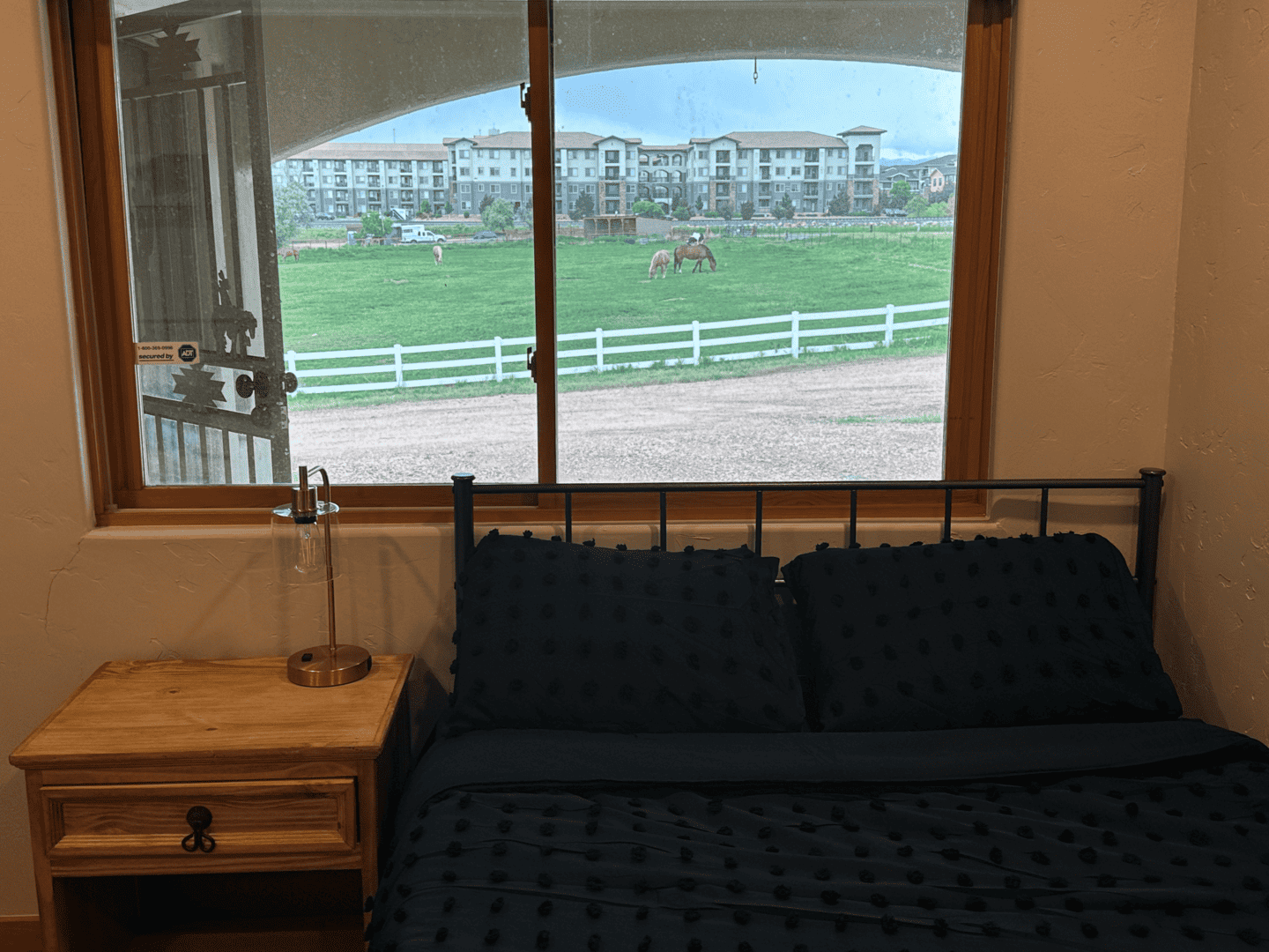 bedroom with nightstand, bed, and view of ranch outside window