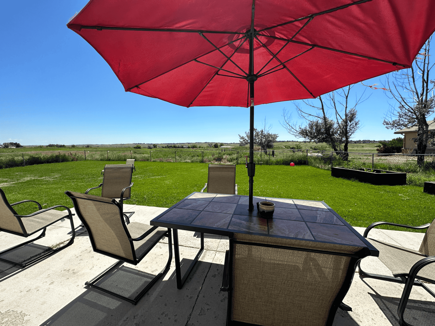 table with red umbrella on outdoor patio