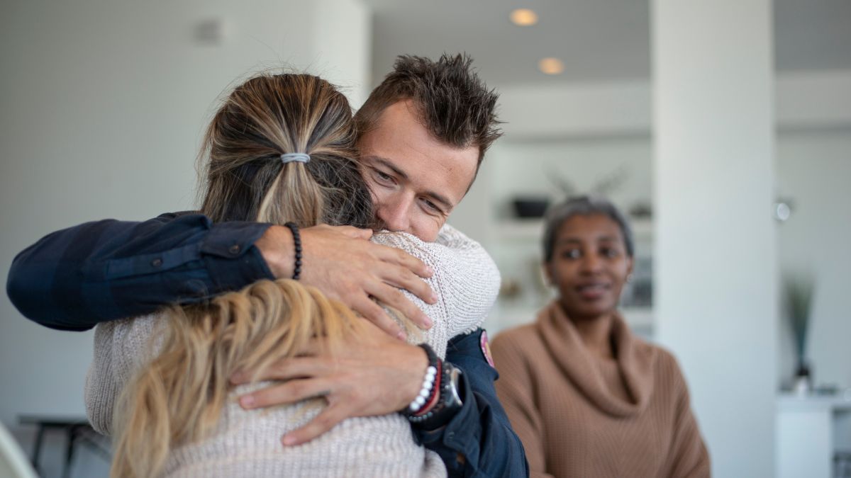 A man hugging a loved one during family therapy at a meth rehab.