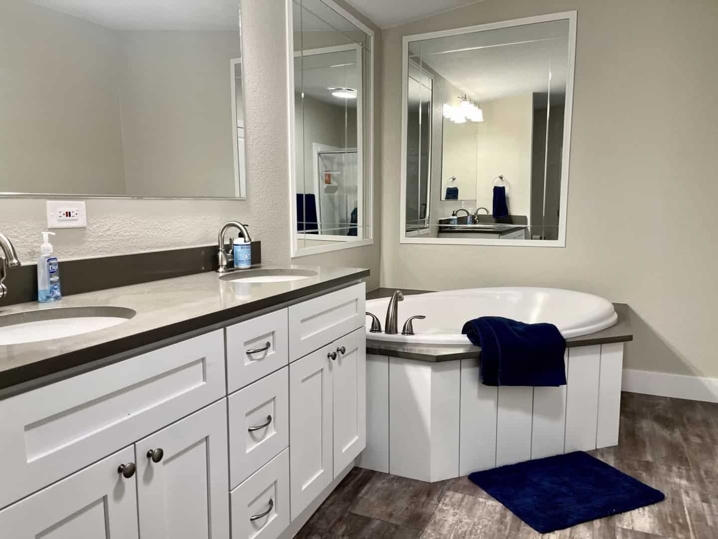 bathroom with tub and dual vanity sinks