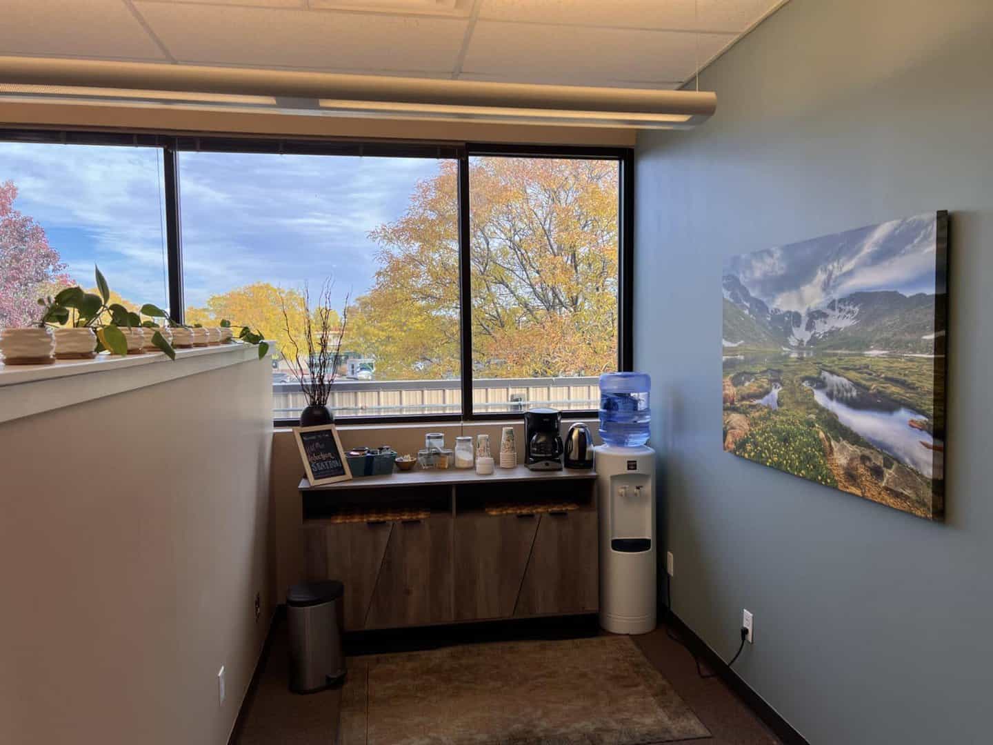 table with coffee maker and water cooler next to it