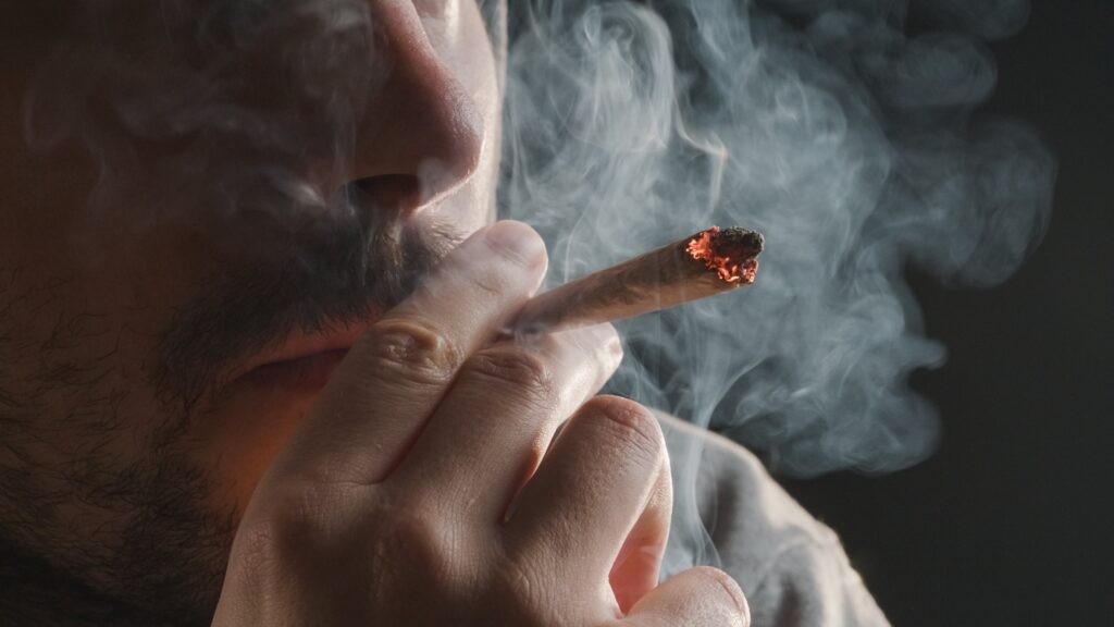 man smoking marijuana cigarette