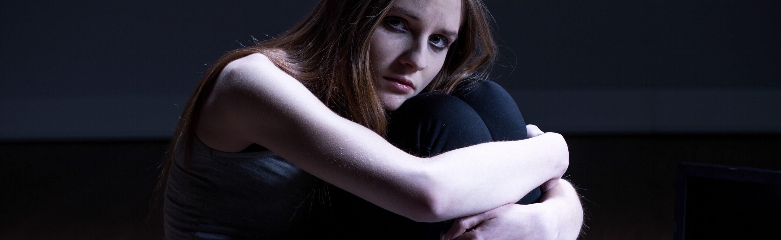 A woman feeling overwhelmed by trauma and addiction.