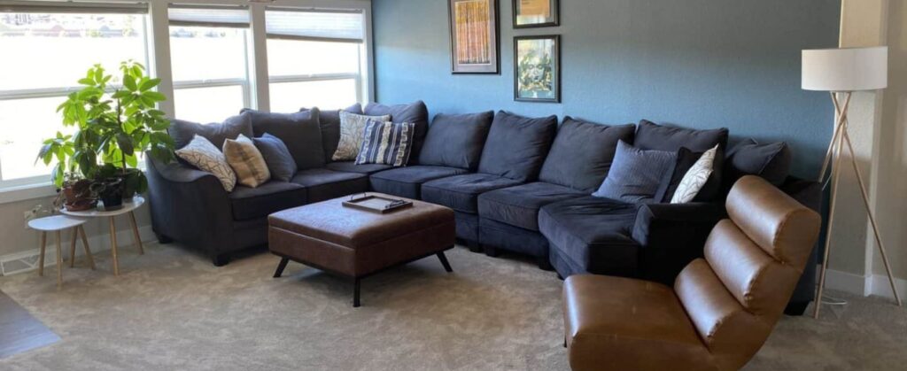 A cozy living room with a big sofa at Flatirons Recovery's luxury rehab in Colorado.