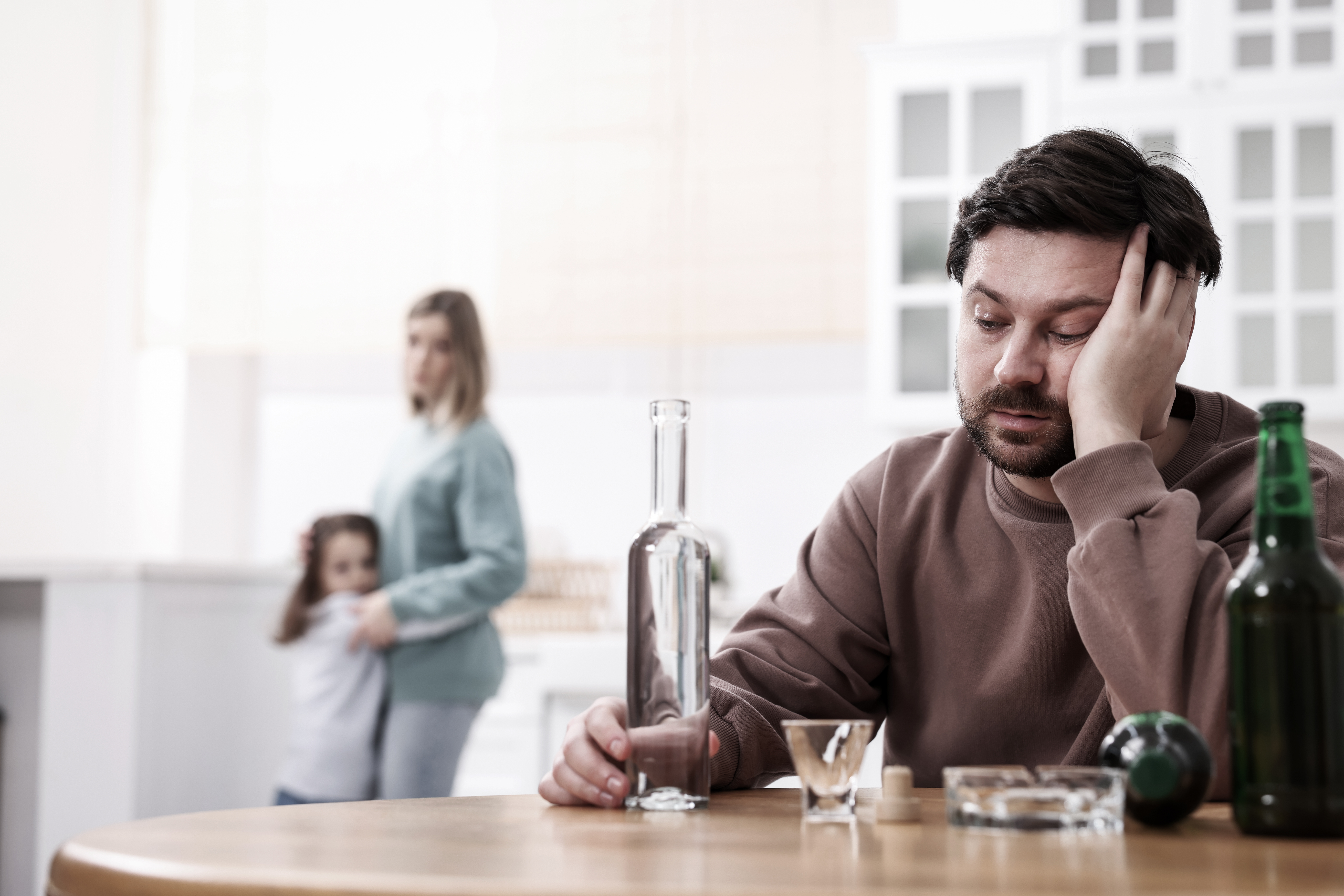Person holding a glass of whiskey while coping with stress drinking and searching for healthier alternatives to alcohol for anxiety.
