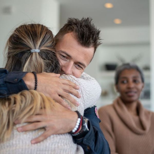 A man hugging a loved one during family therapy at a meth rehab.