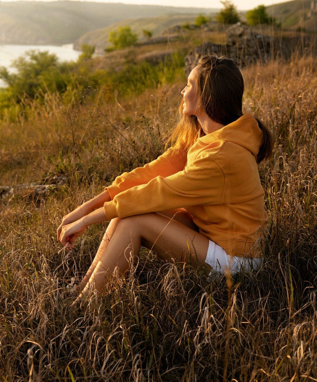 Smiling woman sitting outdoors at sunrise following DBT in Boulder, Colorado.